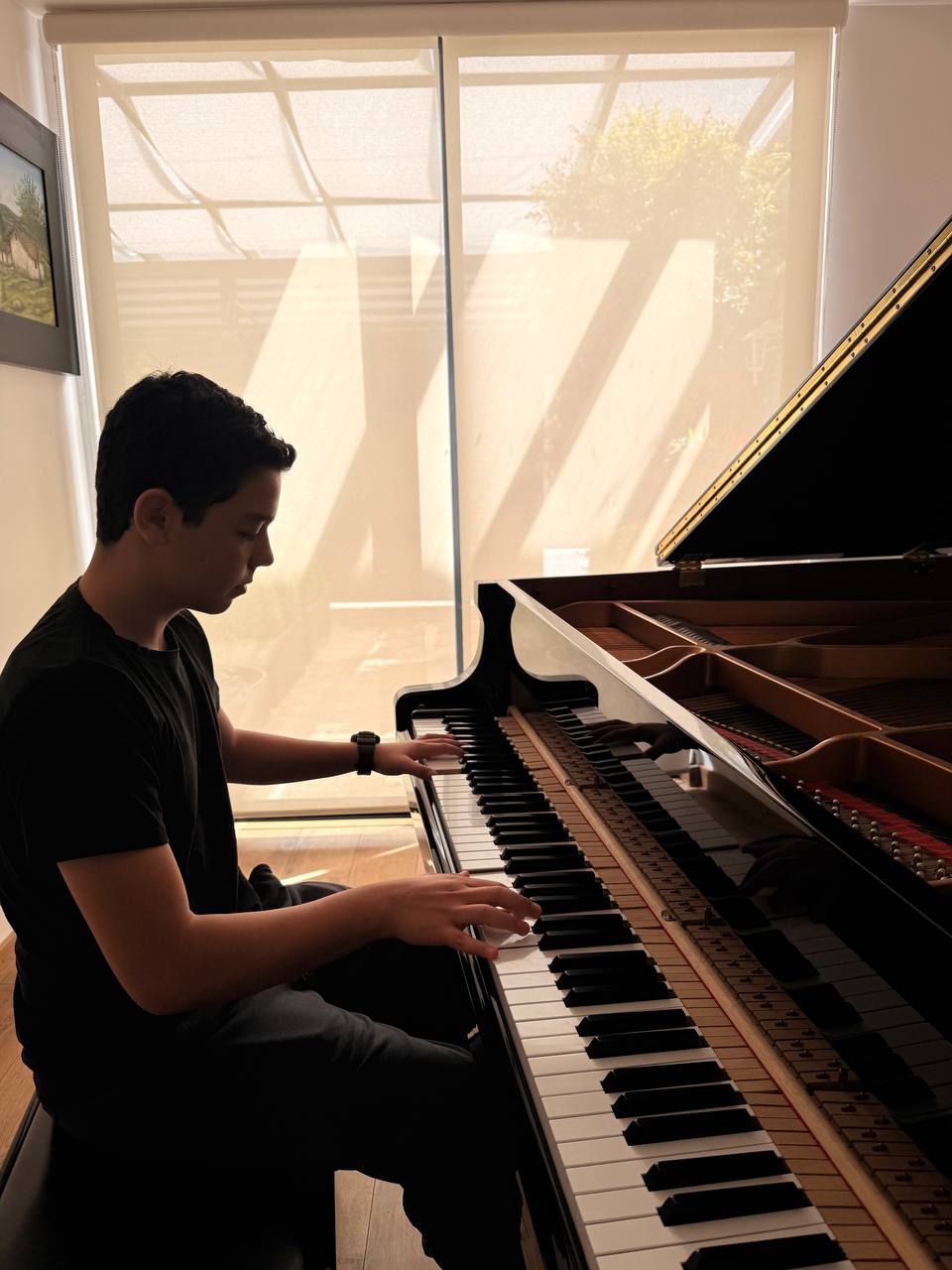 Alumno tocando piano de cola